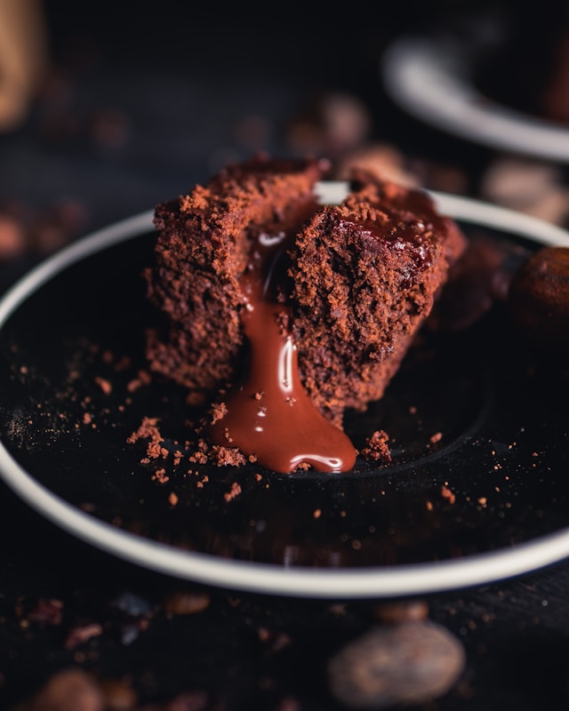 A piece of chocolate cake on a black plate